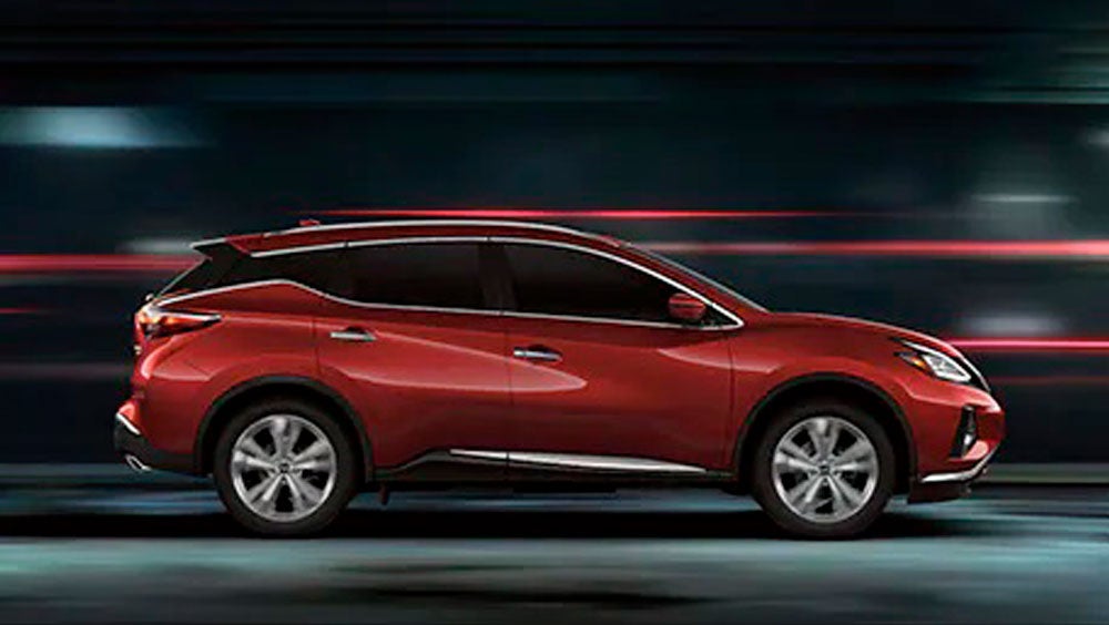 2023 Nissan Murano shown in profile driving down a street at night illustrating performance. | Dutch Miller Nissan in Bristol TN