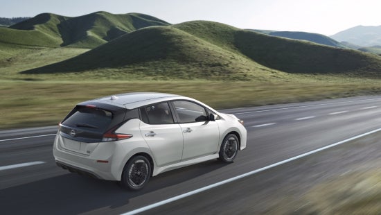 Nissan EV on the road with green hills in the background | Dutch Miller Nissan Of Bristol in Bristol TN