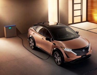 Nissan ARIYA plugged-in and charging outside a home | Dutch Miller Nissan in Bristol TN